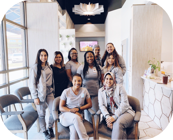 Friendly O2 Dental Group team members posing in the modern reception area, ready to welcome patients.