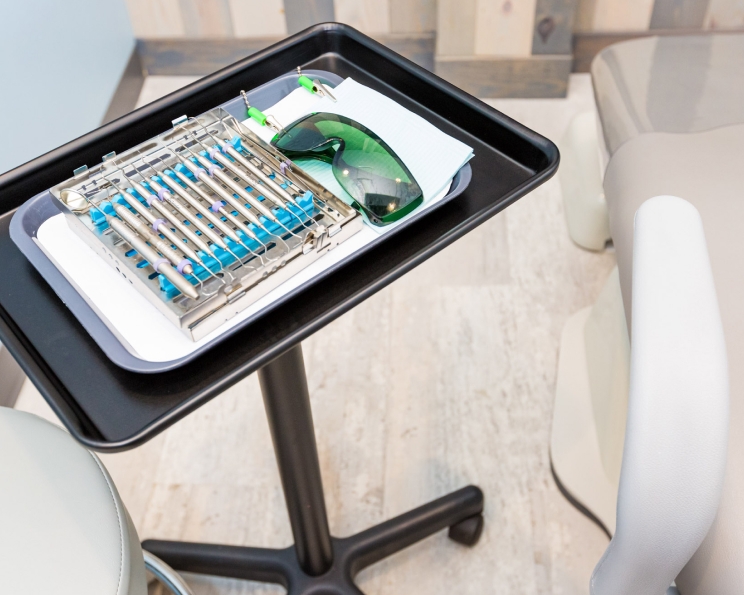 Sterilized dental instrument kit and protective eyewear arranged on a tray, prepared for a safe treatment at O2 Dental Group.